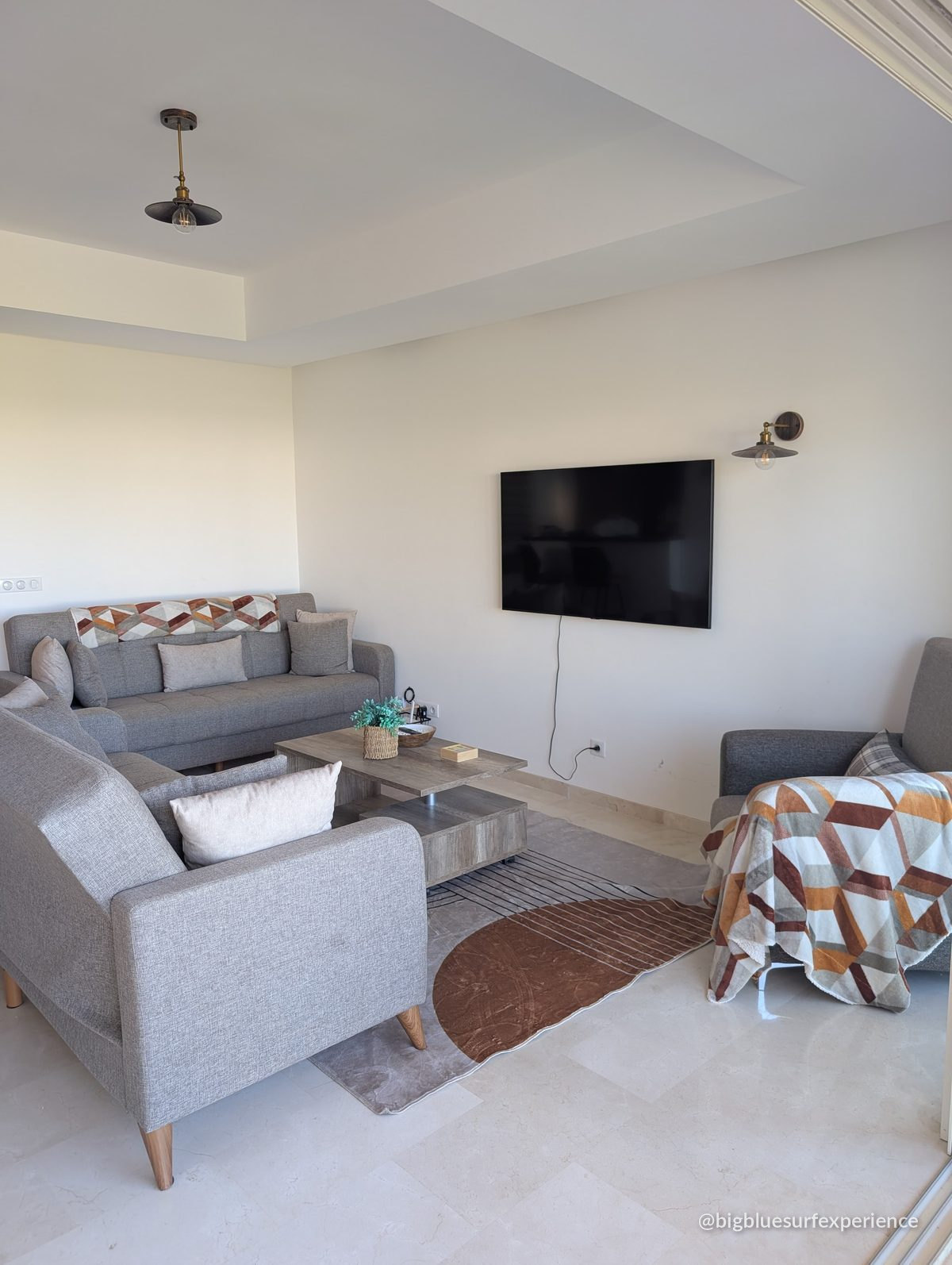 Sofa beds and wall-mounted television in the living room of the BigBlue Bay Studio