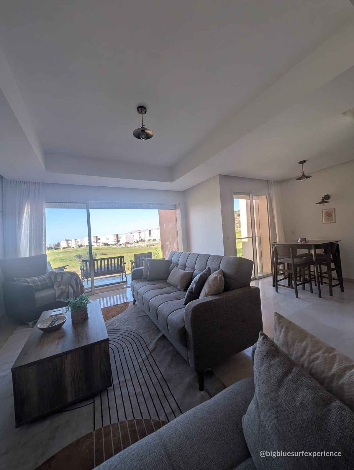 Living room of the BigBlue Bay Studio with two sofa beds and sliding doors onto the balcony